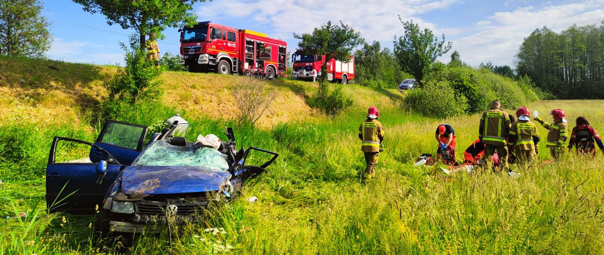 śmiertelny wypadek na DK16 w m. Świackie; na zdjęciu samochód osobowy biorący udział w wypadku, strażacy oraz ratownicy medyczni podczas działań