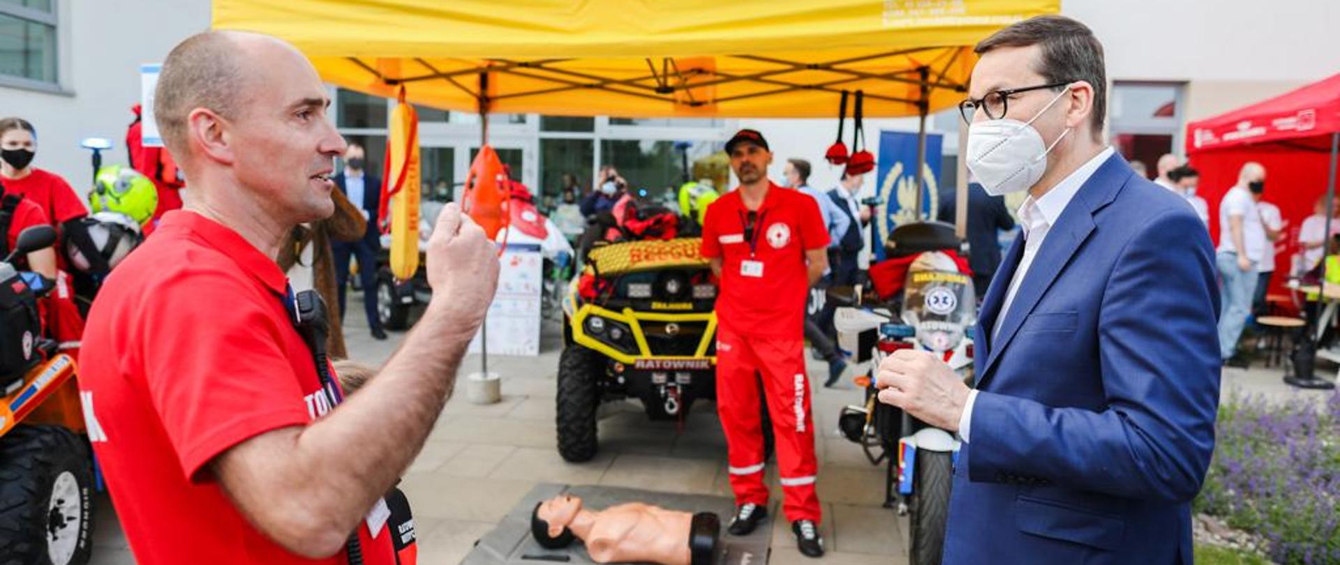 Premier Mateusz Morawiecki rozmawia z ratownikiem medycznym.