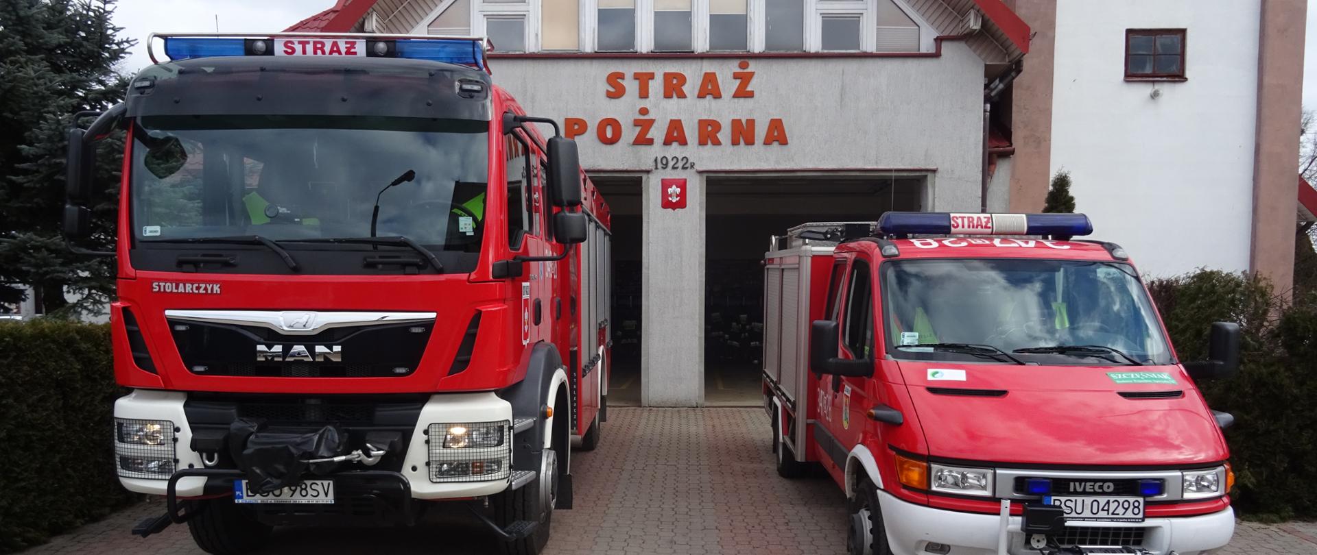 Zdjęcie przedstawia dwa samochody pożarnicze a w tle budynek remizy strażnicy OSP w Raczkach na elewacji budynku widnieje napis straż pożarna 1992 r