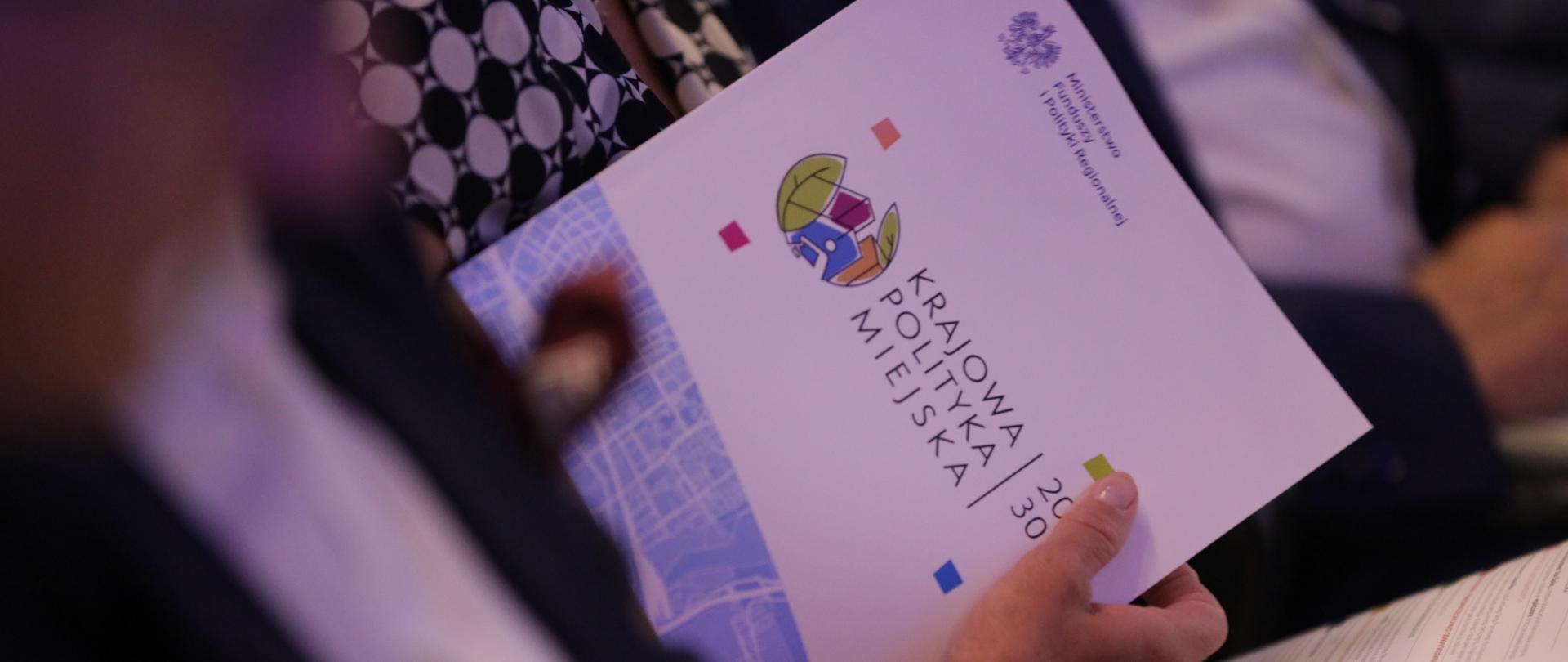 trzymana w ręce Krajowa Polityka Miejska 2030