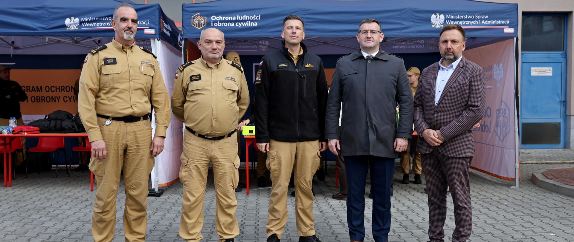 Od lewej stojący Zastępca Komendanta CS PSP następnie stoi Komendant CS PSP oraz trzech mężczyzn pozując do pamiątkowego zdjęcia