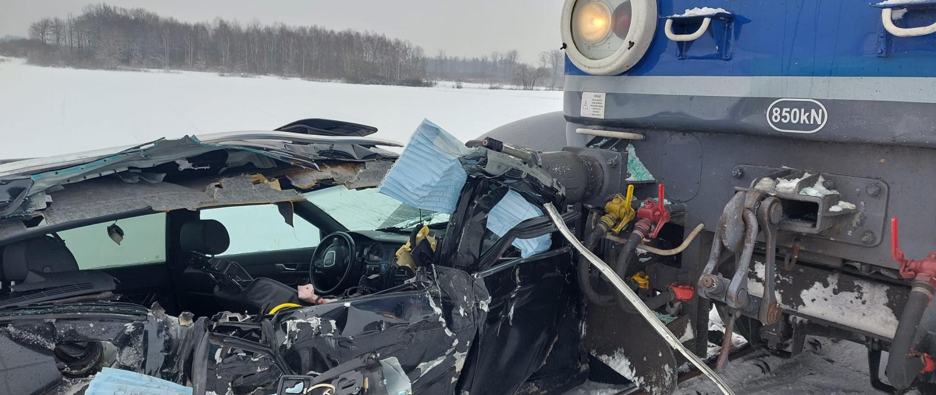 Zdjęcie przedstawia samochód oraz pociąg po zderzeniu.