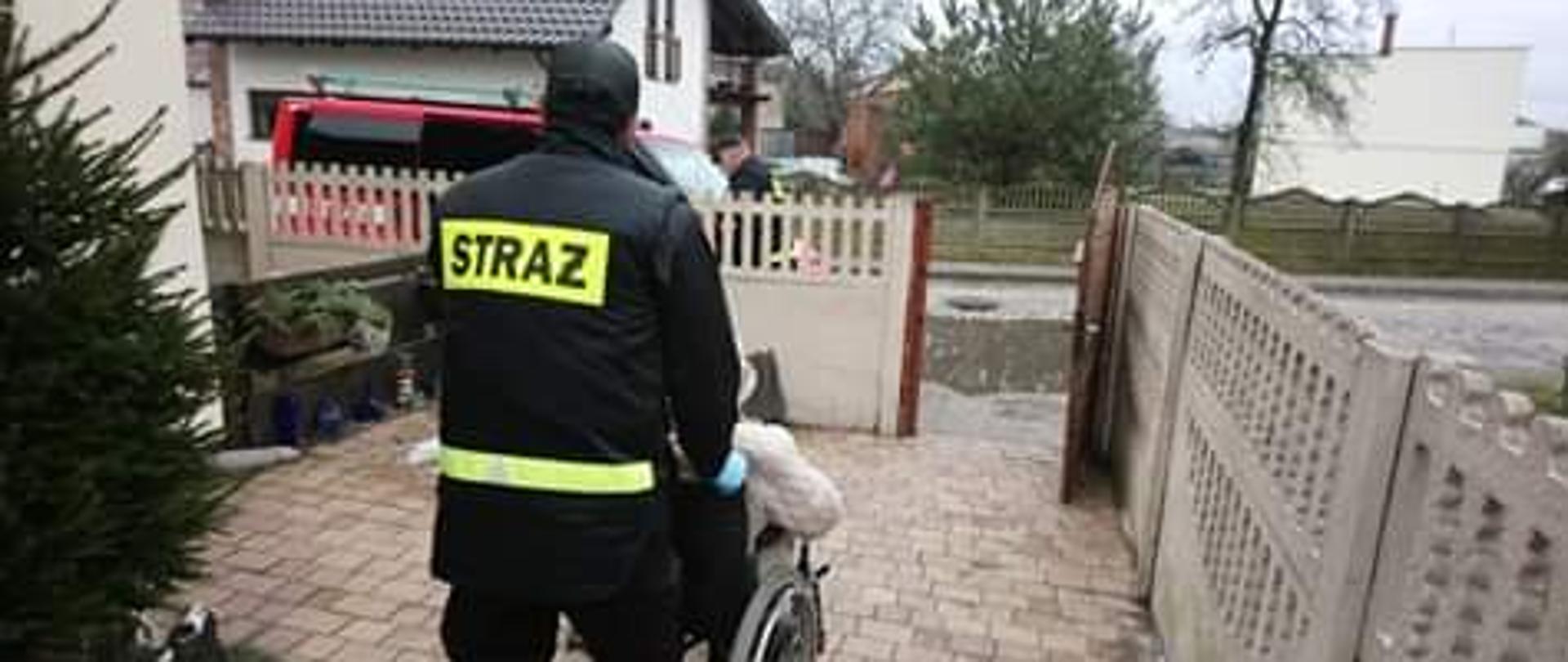 Na zdjęciu druh OSP pomagający w transporcie seniora na szczepienie