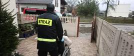 Na zdjęciu druh OSP pomagający w transporcie seniora na szczepienie