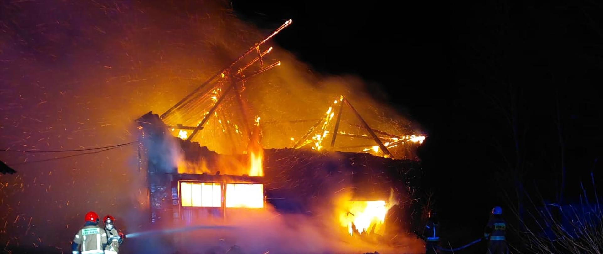 Pożar budynku gospodarczego, cały objęty jest pożarem, pora nocna. 