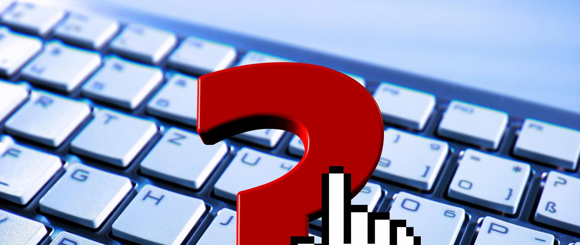 czerwony znak zapytania na tle klawiatury komputera.