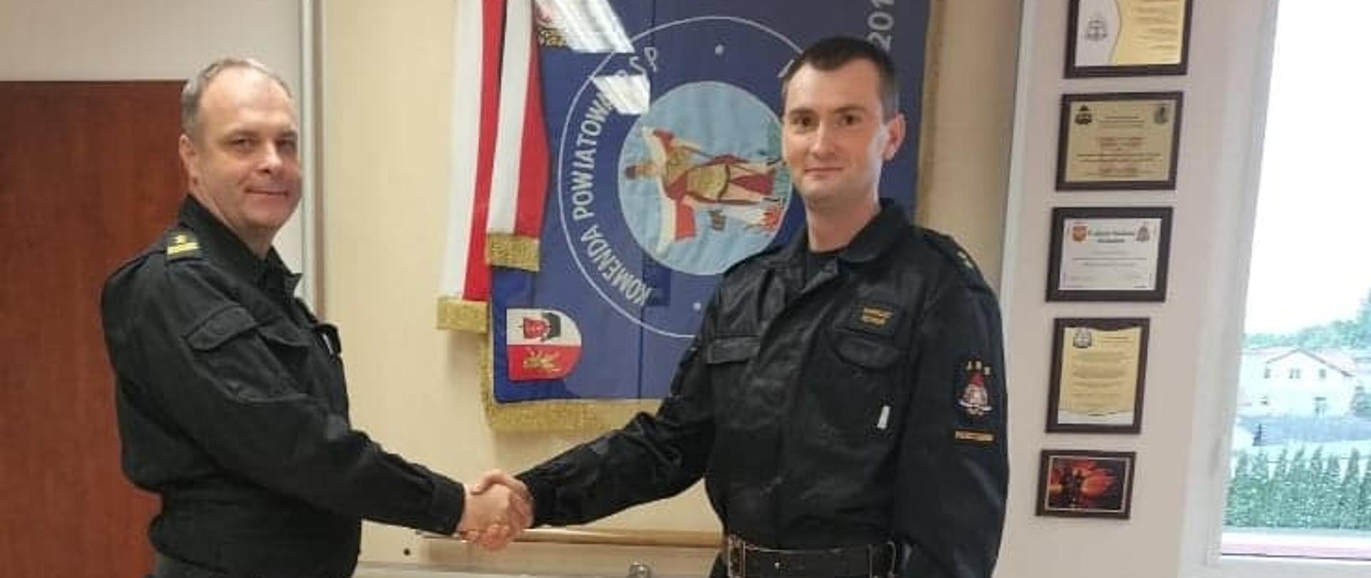 Widzimy dwóch strażaków podczas wręczenia aktu mianowania na stanowisko zastępcy dowódcy JRG