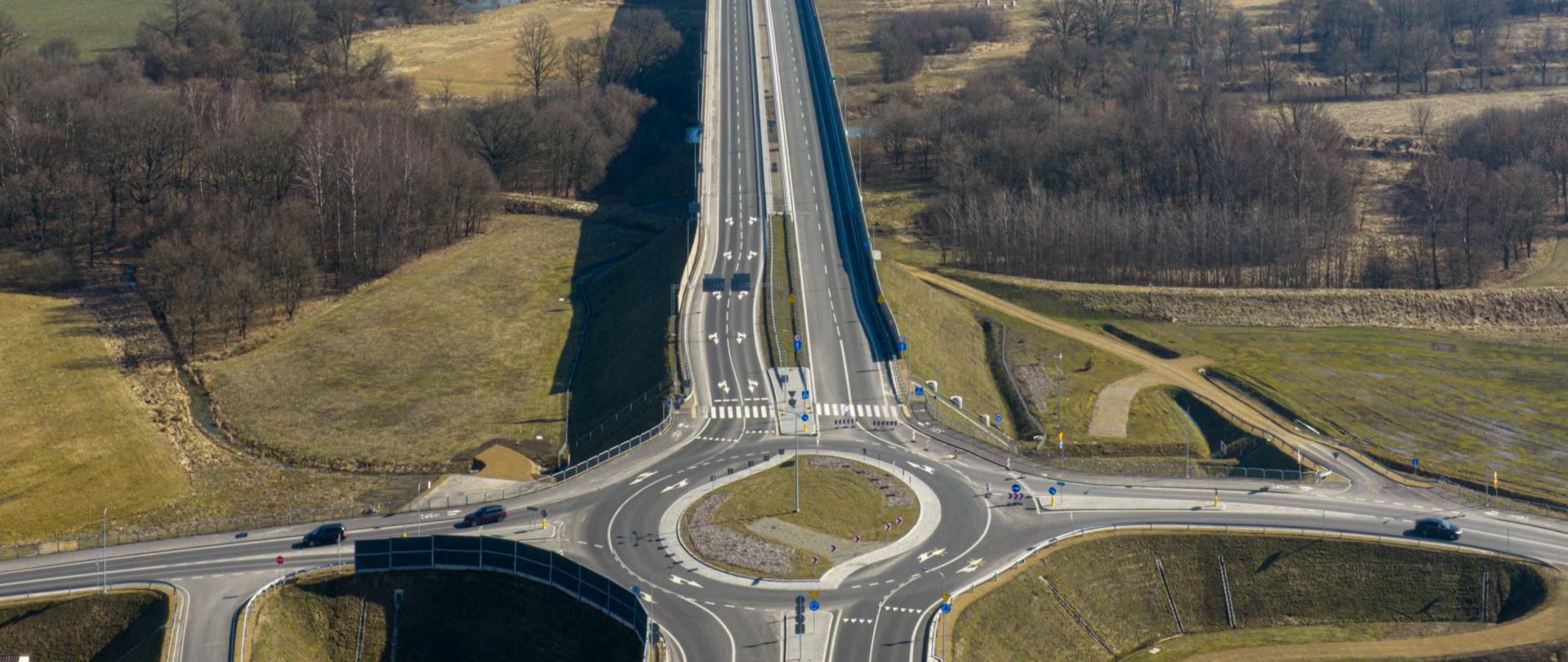 Rondo w Jedlinie, w dalszej części zdjęcia most na Wiśle i obwodnica Oświęcimia, po obu stronach drogi pola, w oddali zabudowania