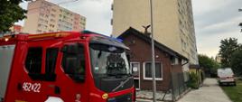 Pojazd GBA 3/29Pr 250 Volvo z Jednostki Ratowniczo Gaśniczej nr 2 na tle budynku w którym doszło do zatrucia tlenkiem węgla