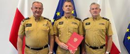 Pomorski Komendant Wojewódzki PSP starszy brygadier Jacek Niewęgłowski wraz ze swoim zastępcą starszym brygadierem Marianem Hincą oraz rzecznikiem w Komendzie Wojewódzkiej PSP w Gdańsku kapitanem Jakubem Friedenberger stoją na tle flag Polskiej i Unijnej.