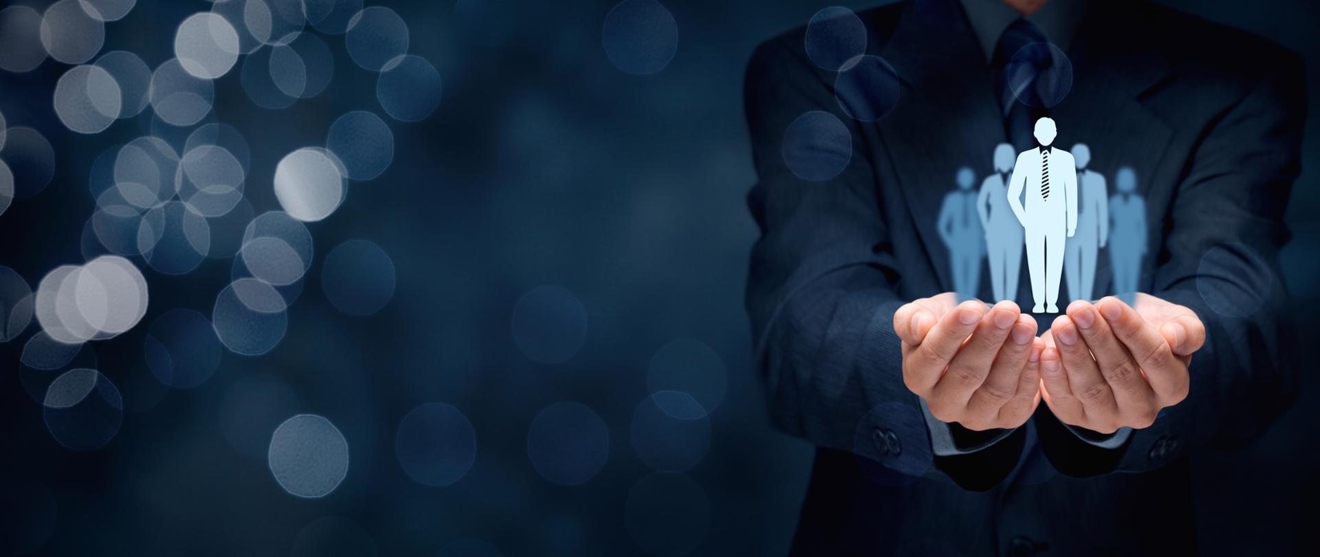 Mężczyzna w marynarce z wyciągniętymi dłońmi a nad nimi widać postacie 