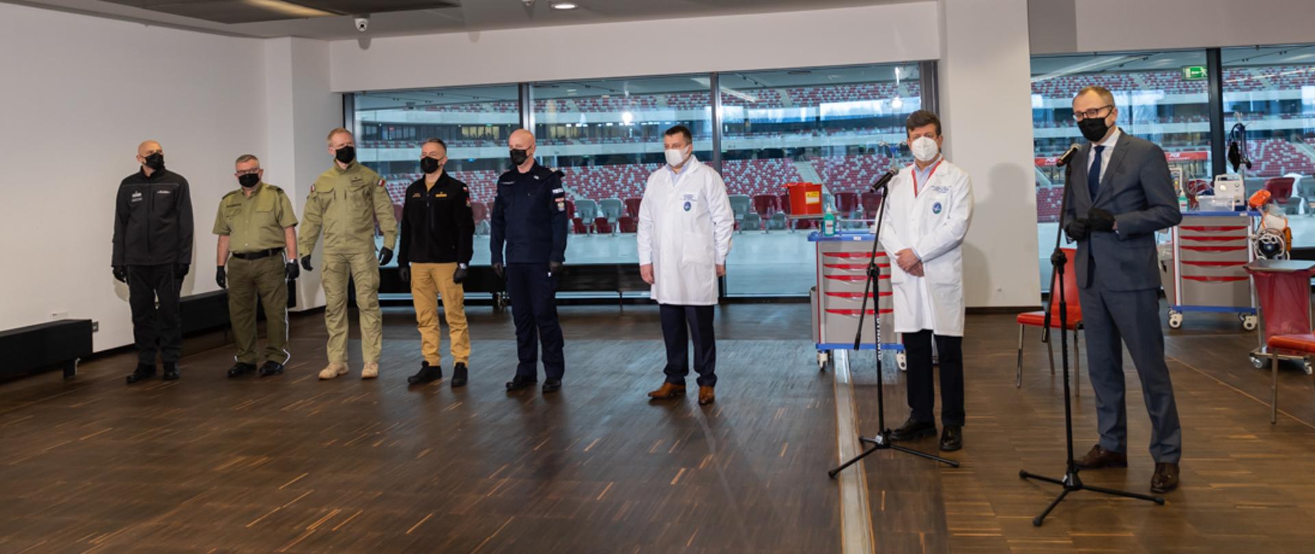 Na zdjęciu znajduja się przedstawiciele służb mundurowych podczas rozpoczęcia procesu szczepień. 