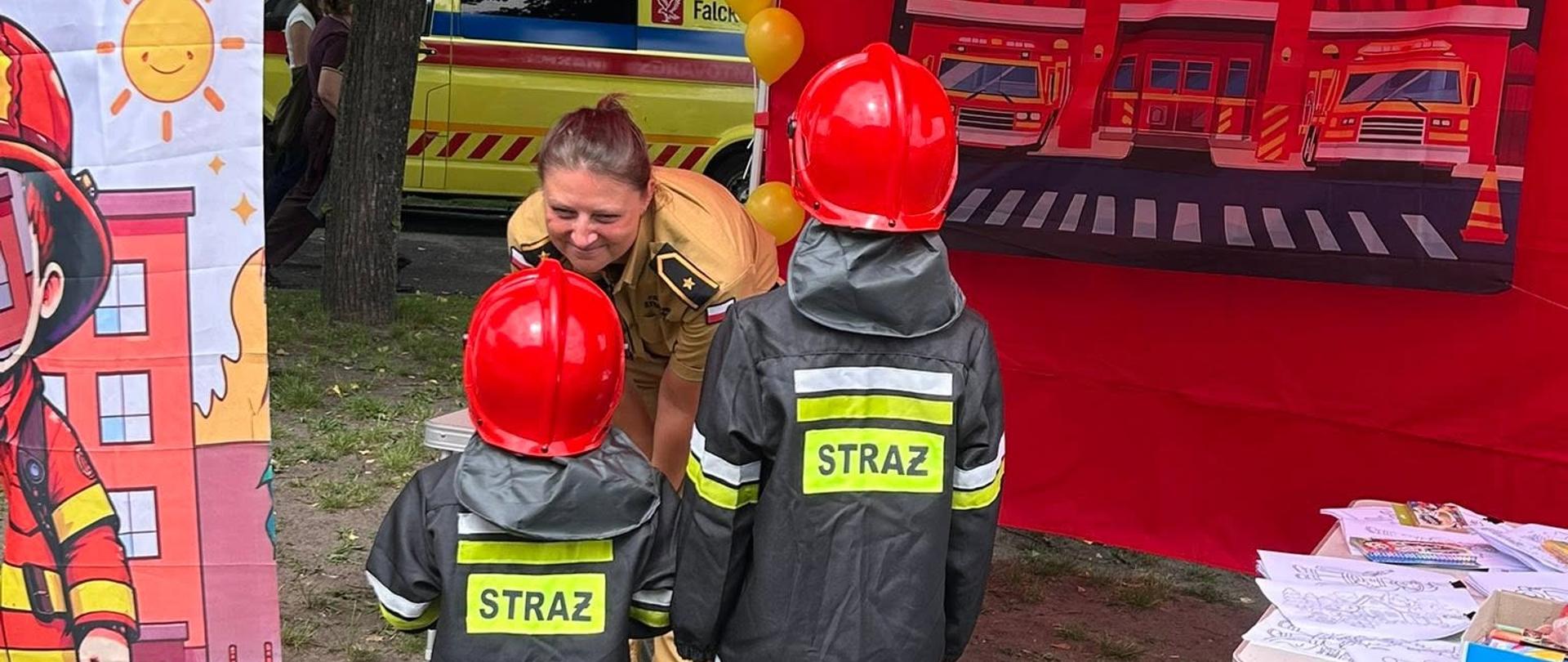 Dzieci poznają zasady bezpieczeństwa na stoisku edukacyjnym straży pożarnej
