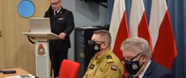 Zdjęcie z narady, na lewo przy mównicy stoi Mazowiecki Komendant Wojewódzki PSP st. bryg. Jarosław Nowosielski, przy stole z prawej strony zdjęcia siedzą Zastępca Komendanta Głównego PSP nadbryg. Krzysztof Hejduk oraz Wicewojewoda Mazowiecki Sylwester Dąbrowski.