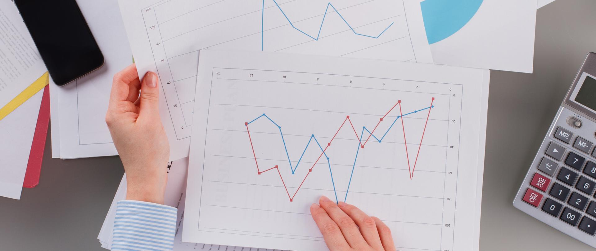 Caucasian businesswoman reviewing data in financial charts and graphs. Close up financial analyst working at office.