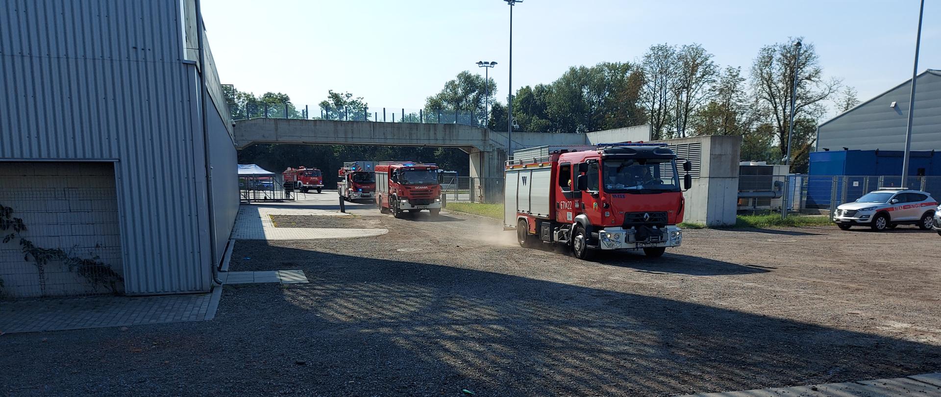 Samochody pożarnicze jadą na sygnałach błyskowych.