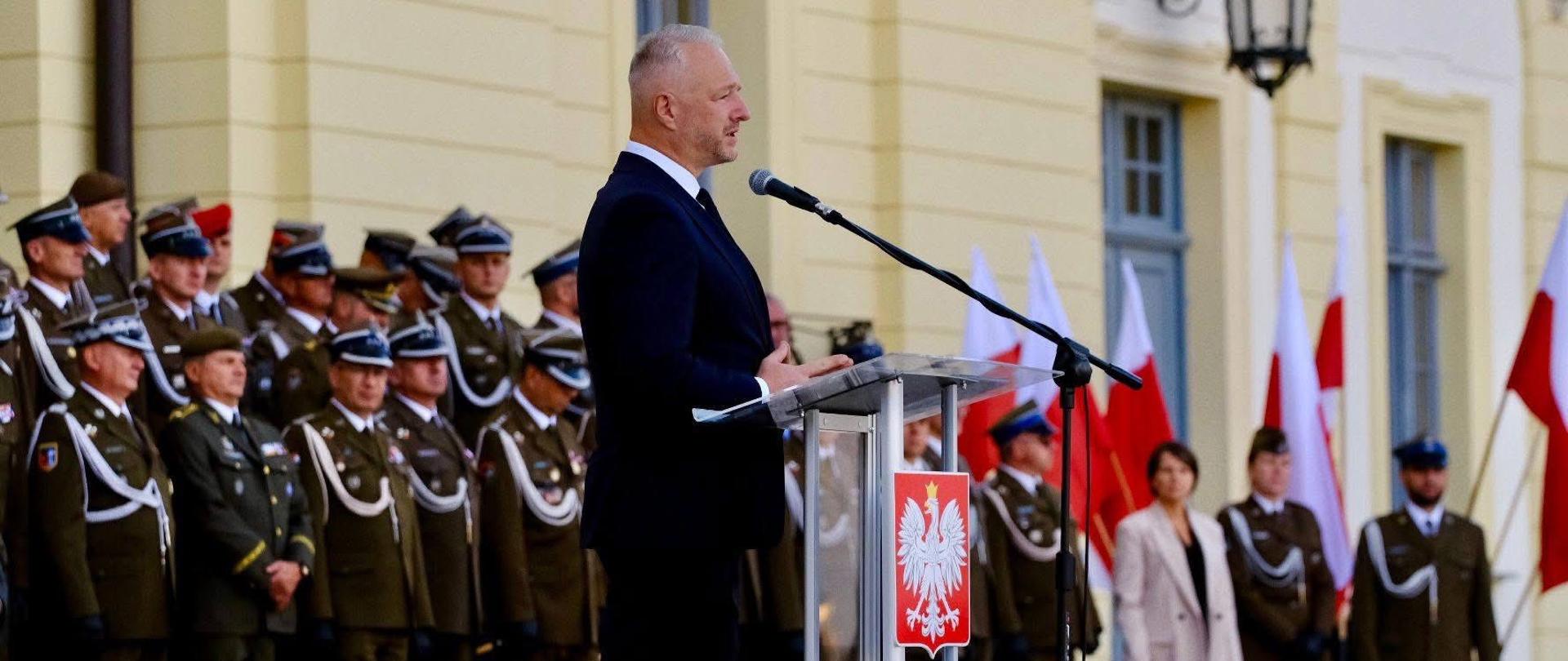 Wojewoda Warmińsko-Mazurski Radosław Król podczas uroczystości 16 DZ w Białymstoku. Wojewoda przemawia z mównicy 