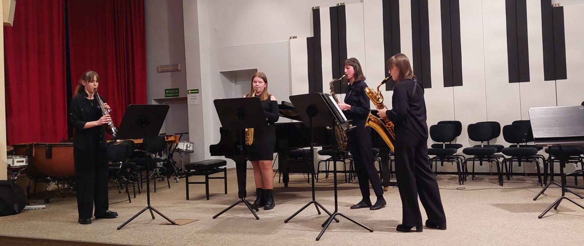 Cztery nastolatki grają na saksofonach