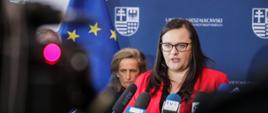 Sekretarz Stanu Małgorzata Jarosińska-Jedynak w konferencji prasowej. W tle widać kobietę.