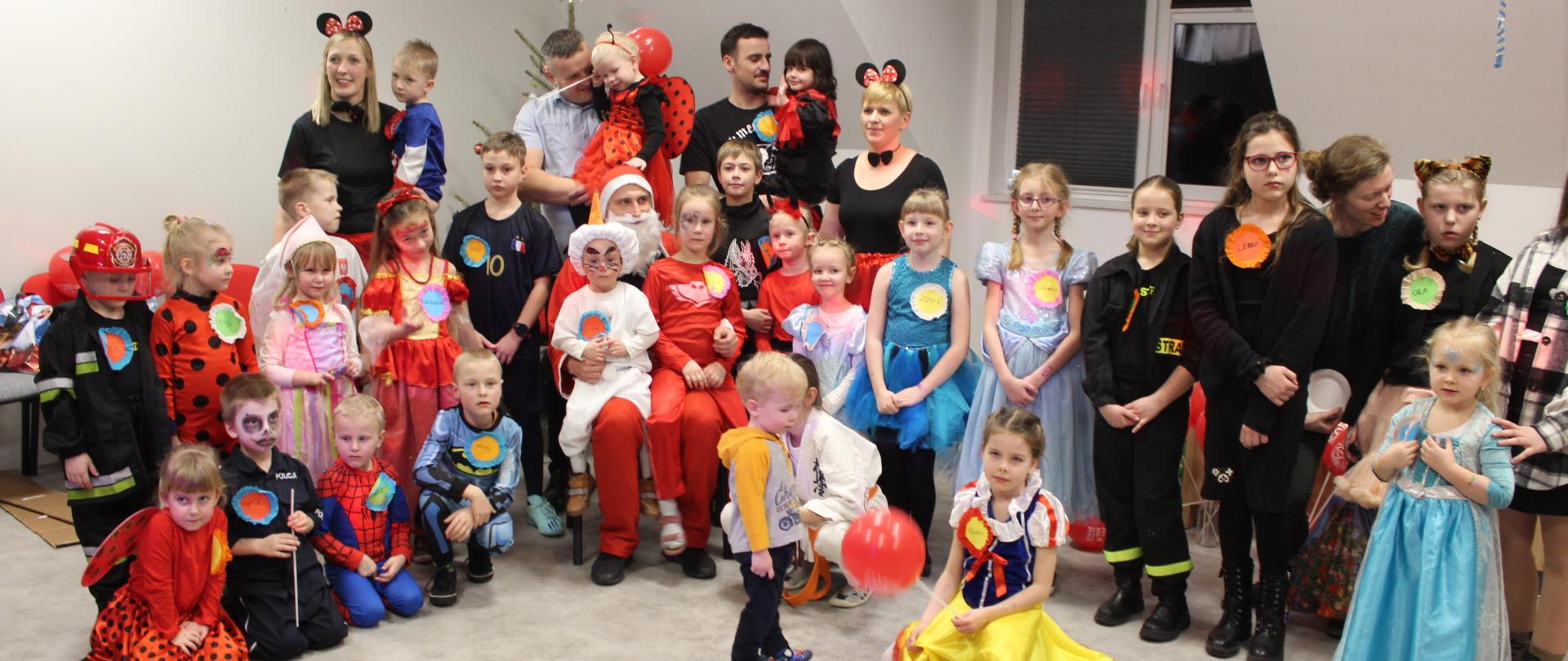 W świetlicy Komendy Powiatowej Państwowej Straży Pożarnej w Świeciu pozują do zdjęcia uczestnicy Balu Karnawałowego zorganizowanego dla dzieci strażaków. 