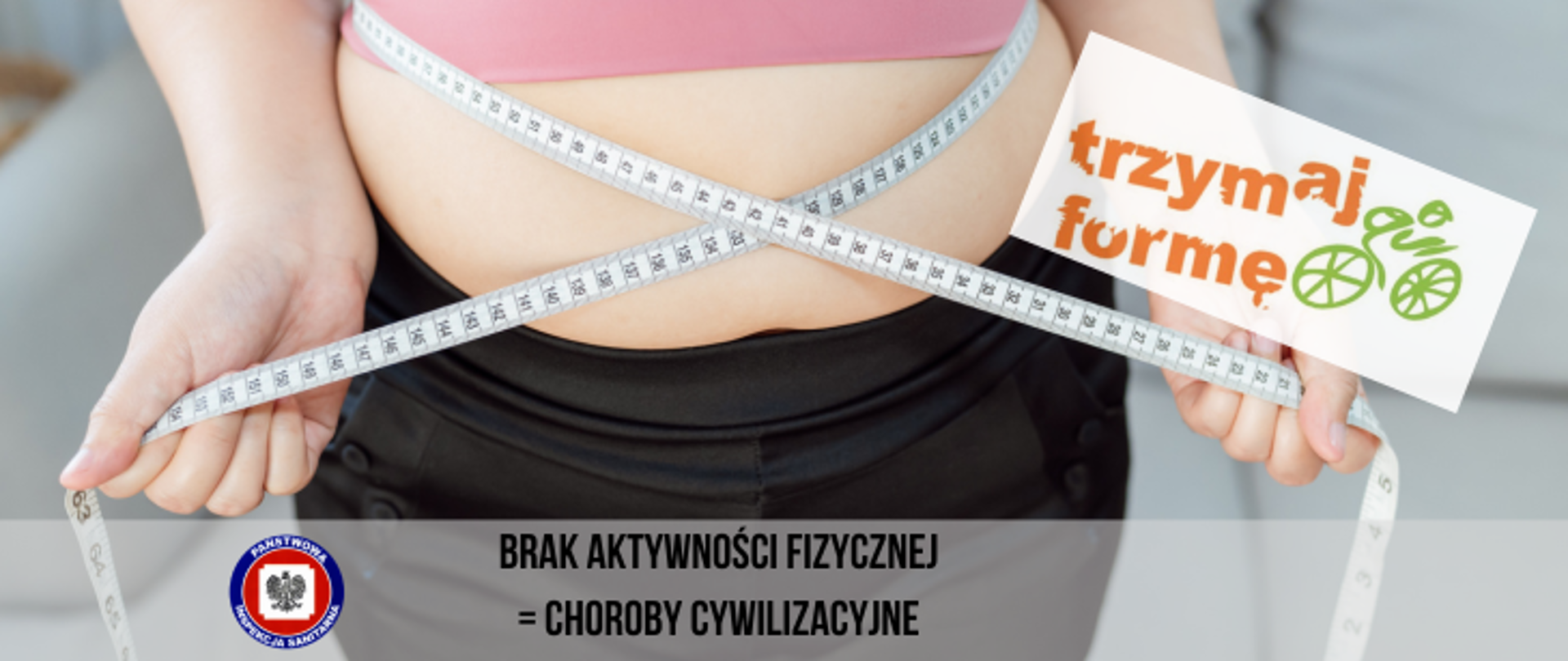 Pani w czarnych szortach i różowej bluzce mierzy obwód pasa miarą krawiecką, z prawej stronie na jasnym tle pomarańczowy napis trzymaj formę i zielony kolarz, na dole półprzezroczysty pasek z ciemnym napisem brak aktywności fizycznej=choroby cywilizacyjne a z jego lewej strony logo Państwowej Inspekcji Sanitarnej. 