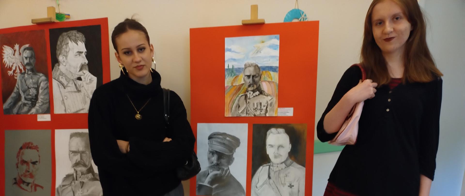 Dwie dziewczyny pozują na tle portretów J. Piłsudskiego. Portrety są oprawione w antyramy po 3- i po 4- , na czerwonym tle, stoją na drewnianych sztalugach.