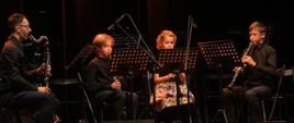 Zdjęcie przedstawiający kwartet klarnetowy PSM I stopnia w Jarocinie występujący podczas koncertu klarnetowego. Na scenie od lewej: Rafał Gubański, Franciszek Sobański, Hanna Andrzejczak i Adam Andrzejczak.