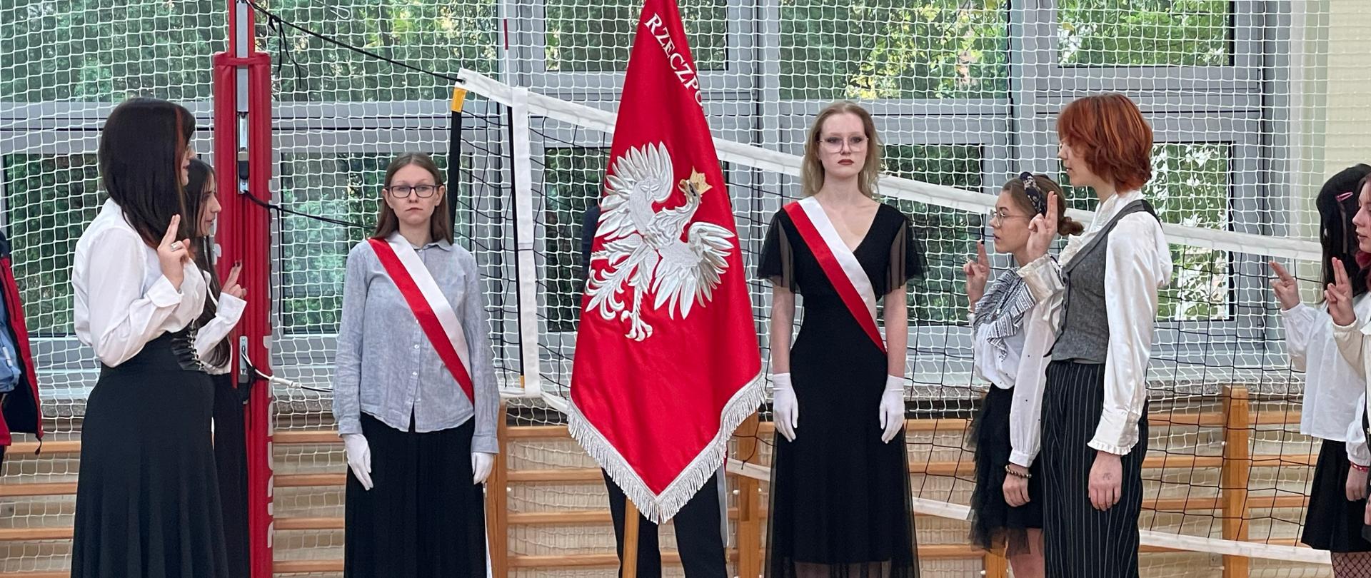 Uczniowie klas pierwszych składają ślubowanie na sali gimnastycznej przy poczcie sztandarowym