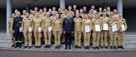 Pamiątkowe zdjęcie grupowe funkcjonariuszy PSP kończących szkolenie p[odstawowe w zawodzie strażak (36 osób) w towarzystwie Zastępcy Komendanta Centralnej Szkoły PSP, funkcjonariuszki CS PSP oraz dwóch funkcjonariuszy CS PSP