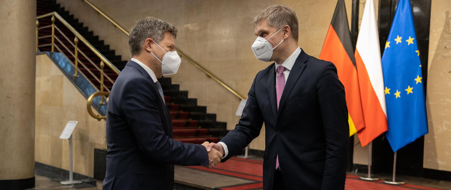 Robert Habeck i Piotr Nowak witają się podaniem dłoni.