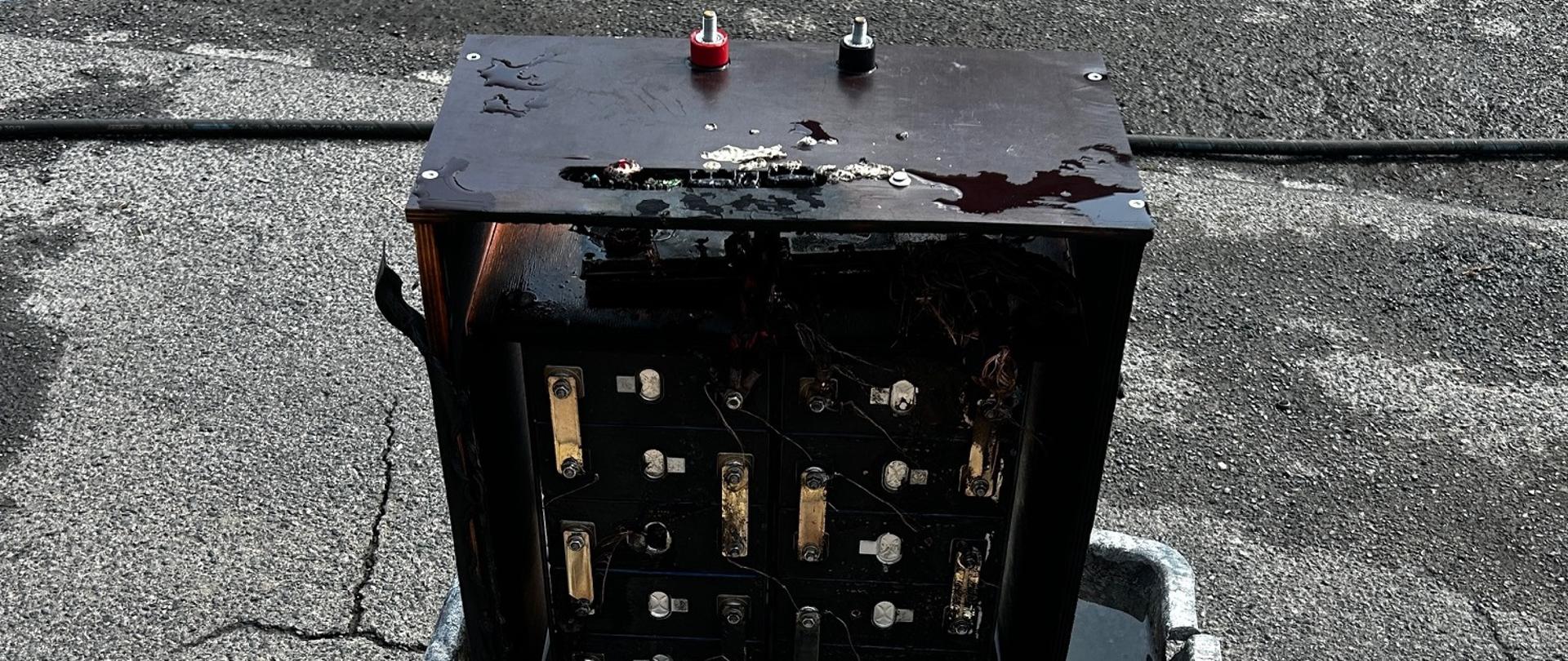 W zbiorniku z wodą stoi nadpalony duży akumulator