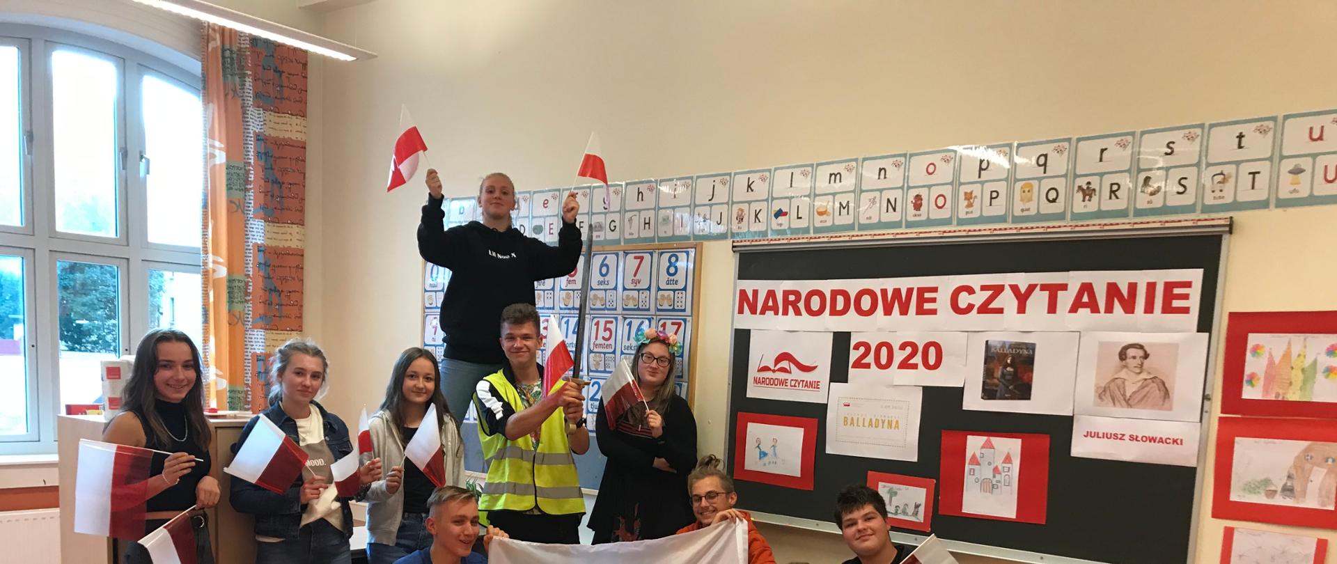 Starsze dzieci machające polskimi flagami