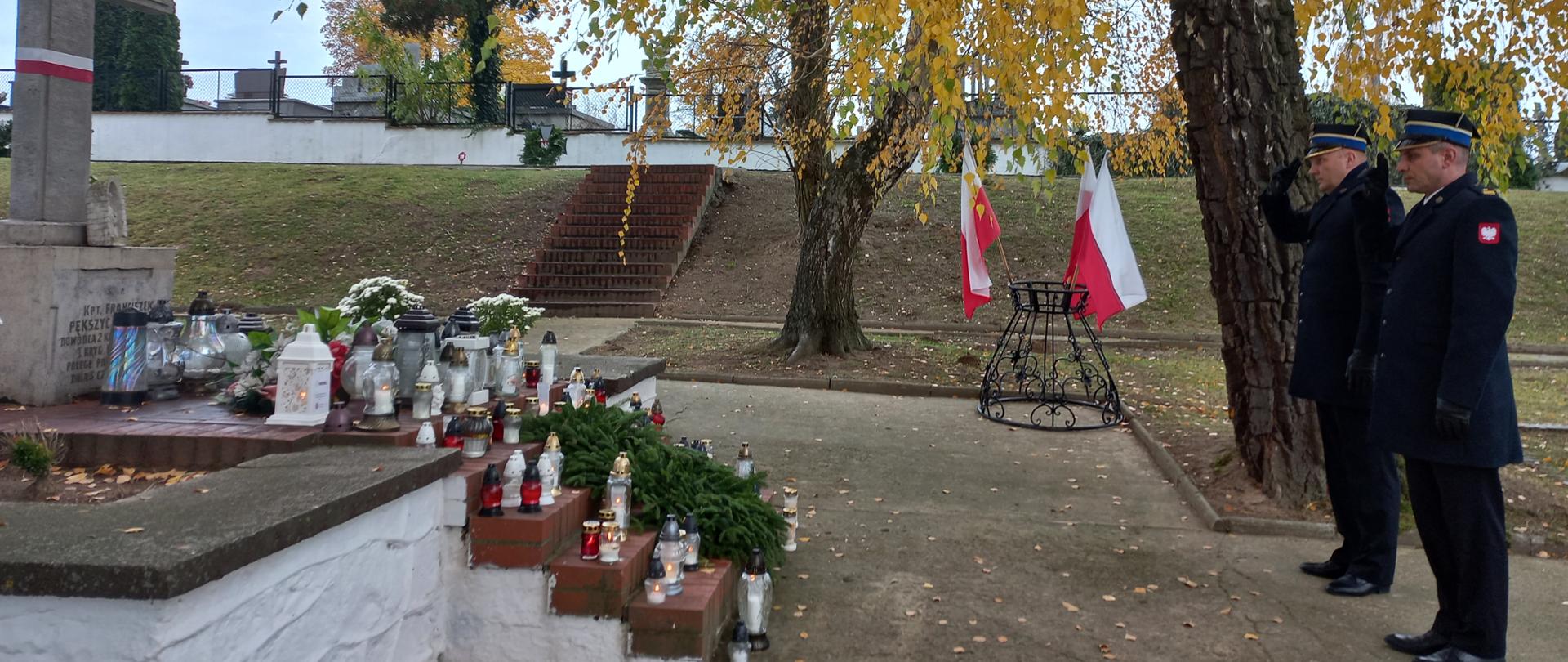 Strażacy oddający honory na grobach powstańców 