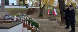 Strażacy oddający honory na grobach powstańców 