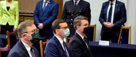 Na krzesłach siedzą premier Rzeczypospolitej Polskiej, rzecznik rządu oraz przedstawiciel rządu.