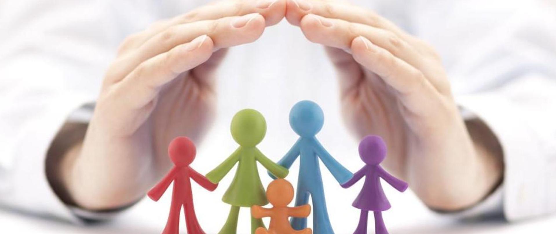Na zdjęciu widoczne są dłonie złożone jak parasol chroniące pięć ludzików wykonanych z plasteliny w kolorach czerwonym, zielonym, niebieskim, brązowym, fioletowym.