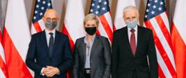 Od lewej: minister Michał Kurtyka, Jennifer Granholm oraz Piotr Naimski stoją na tle flag Polski oraz flag USA.