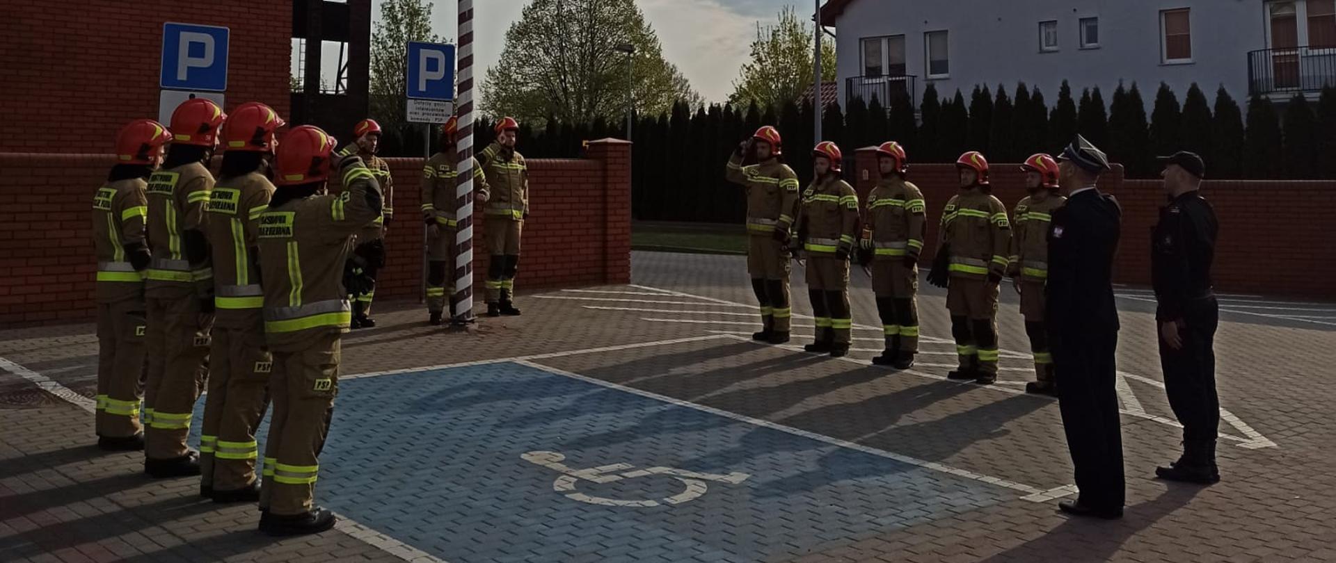 Funkcjonariusz stoją przed masztem na który wciągana jest flag narodowa 