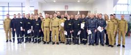 Grupowe zdjęcie uczestników szkolenia w towarzystwie Komendanta oraz nowego Zastępcy Komendanta Centralnej Szkoły PSP, kobiety oraz pięciu funkcjonariuszy CS PSP