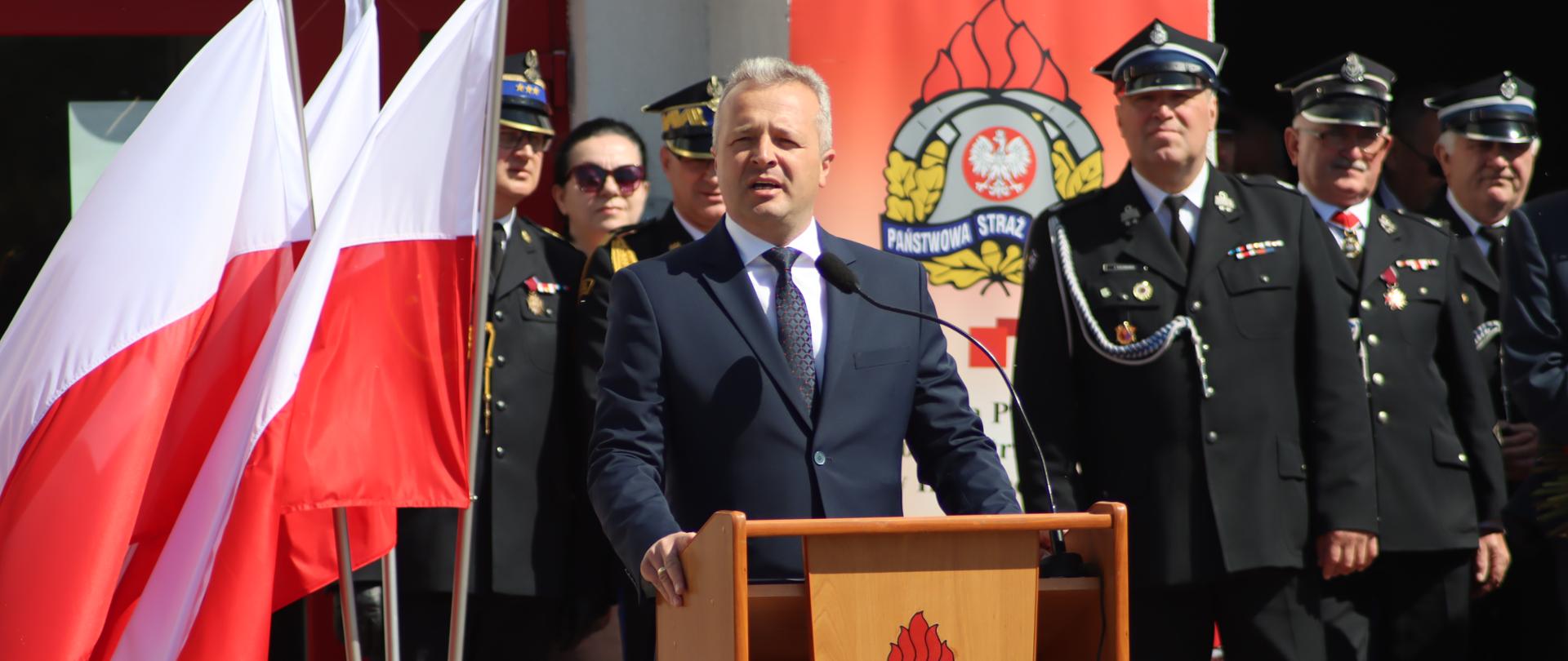 Jeden mężczyzna stojący przy mównicy i wypowiadający się