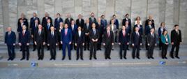 Ministrowie i Sekretarz Generalny stoją w trzech rzędach i pozują do wspólnego zdjęcia uczestników spotkania