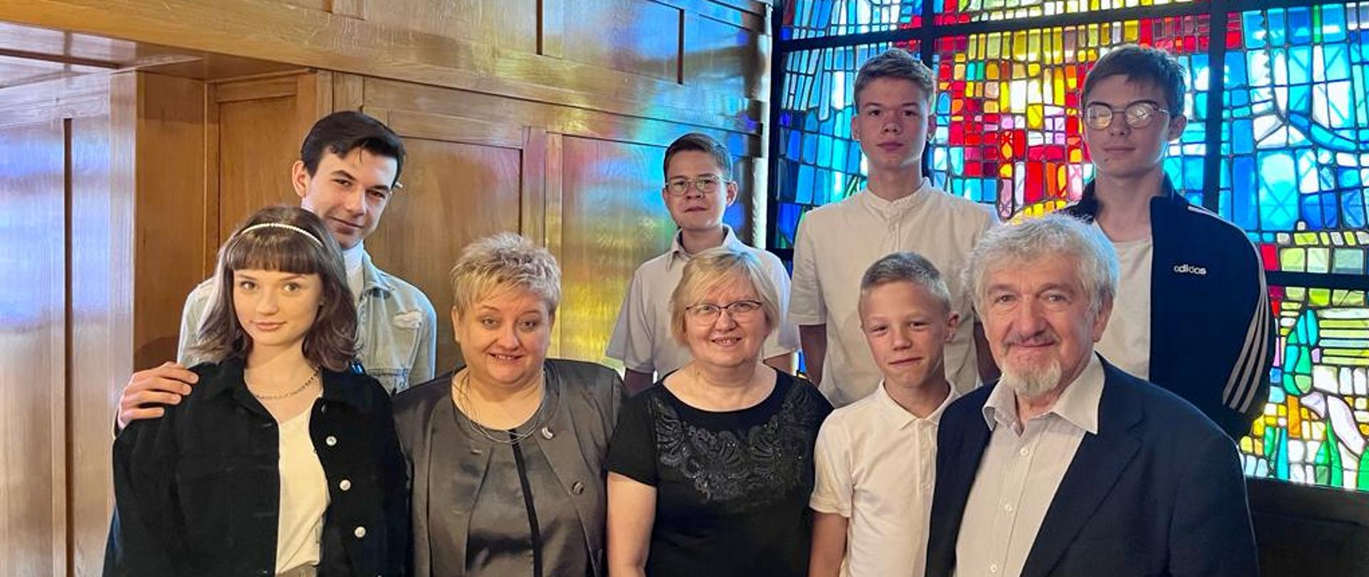 Uczestnicy warsztatów razem z prof. Julianem Gembalskim w tle organy i witraż