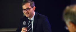 Wiceminister rozwoju i technologii Marek Niedużak z mikrofonem w ręku przemawiający podczas obrad EFNI'21 w Sopocie