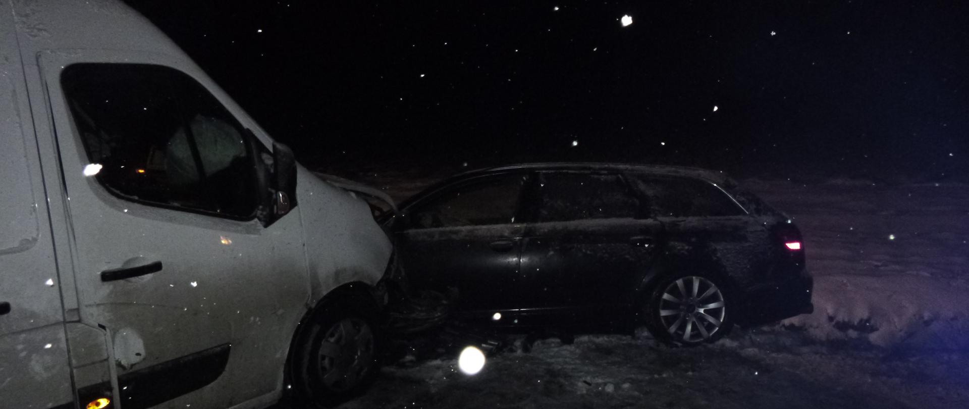 Zderzony bus i samochód osobowy w śnieżnej, wieczornej aurze.