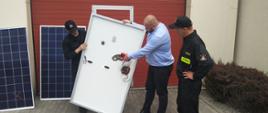 Wykładowca przedstawia strażakom budowę panelu fotowoltaicznego.