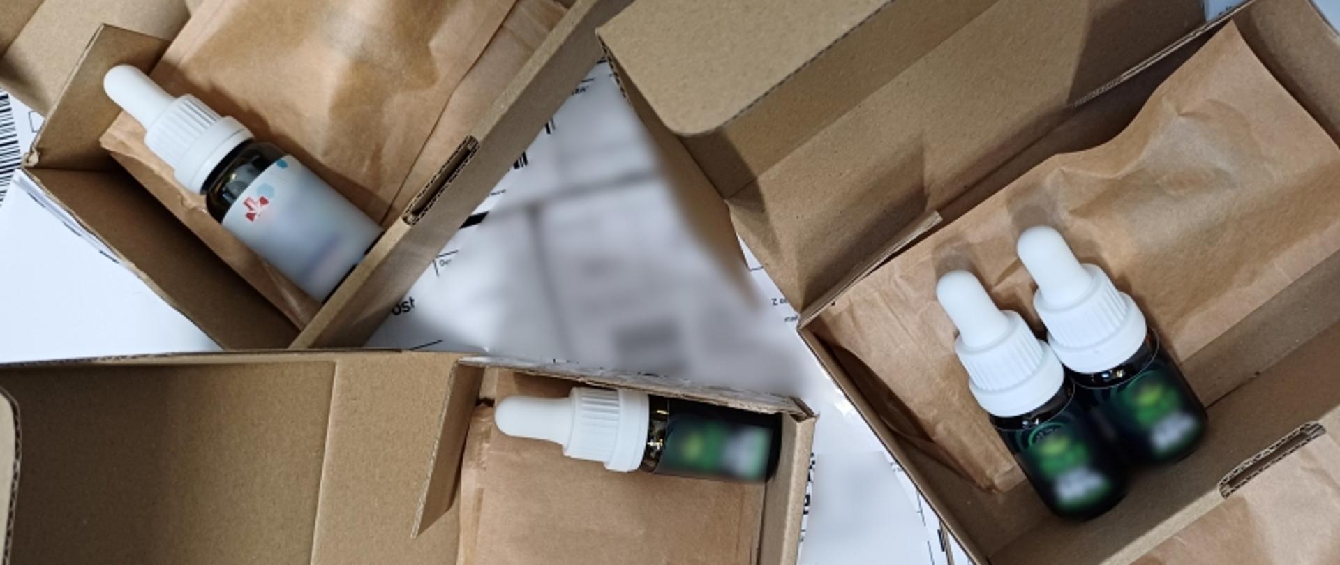 brązowe kartoniki i trzy buteleczki koloru zielonego