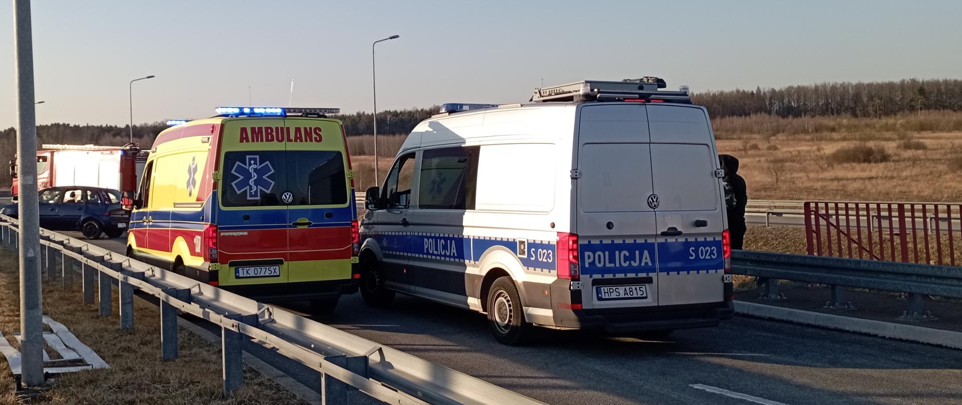  Na zdjęciu przedstawiono zaaranżowaną akcję ratowniczą. Samochody służb ratowniczych zamknęły drogę i stoją w kolejności: Policja, Państwowe Ratownictwo Medyczne, uszkodzony samochód osobowy i Państwowa Straż Pożarna.