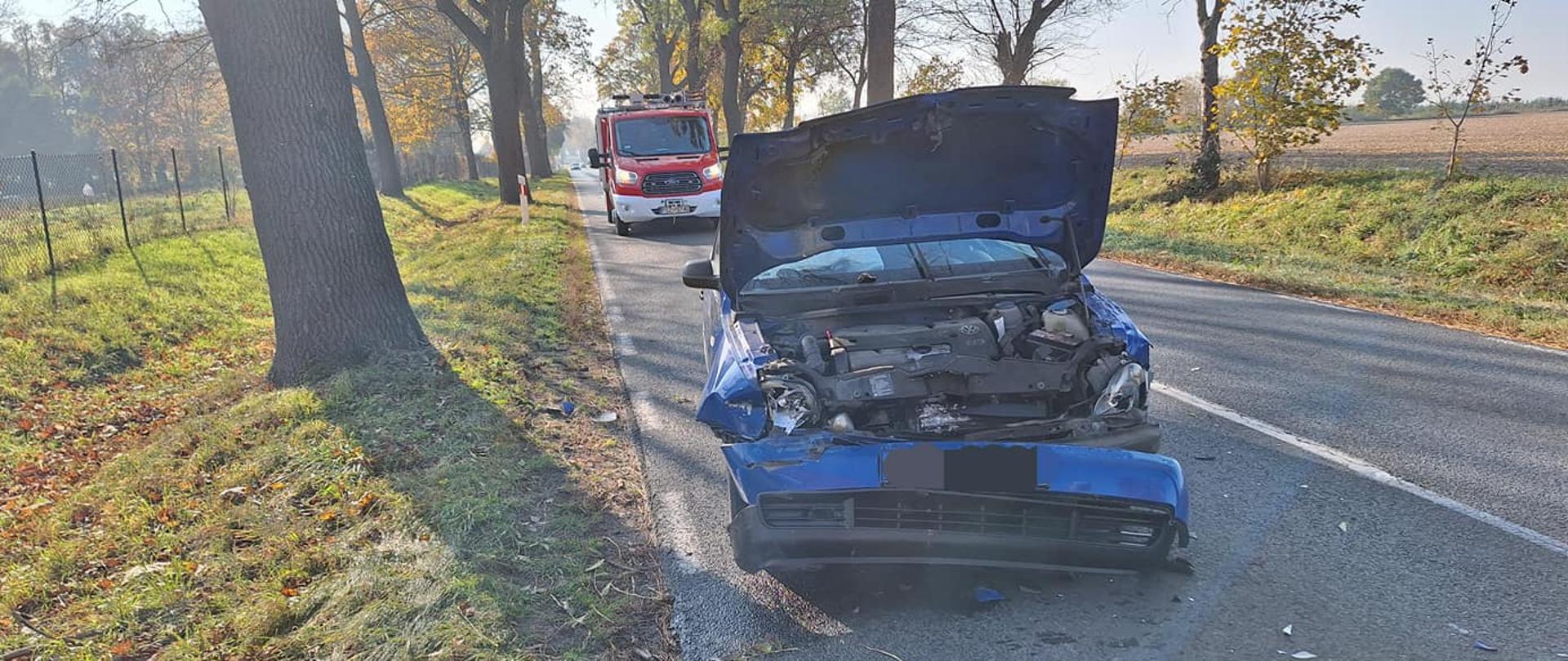 Uszkodzony samochód osobowy na drodze, podniesiona maska