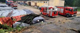 Na posesji samochody strażackie, uszkodzony dach budynku