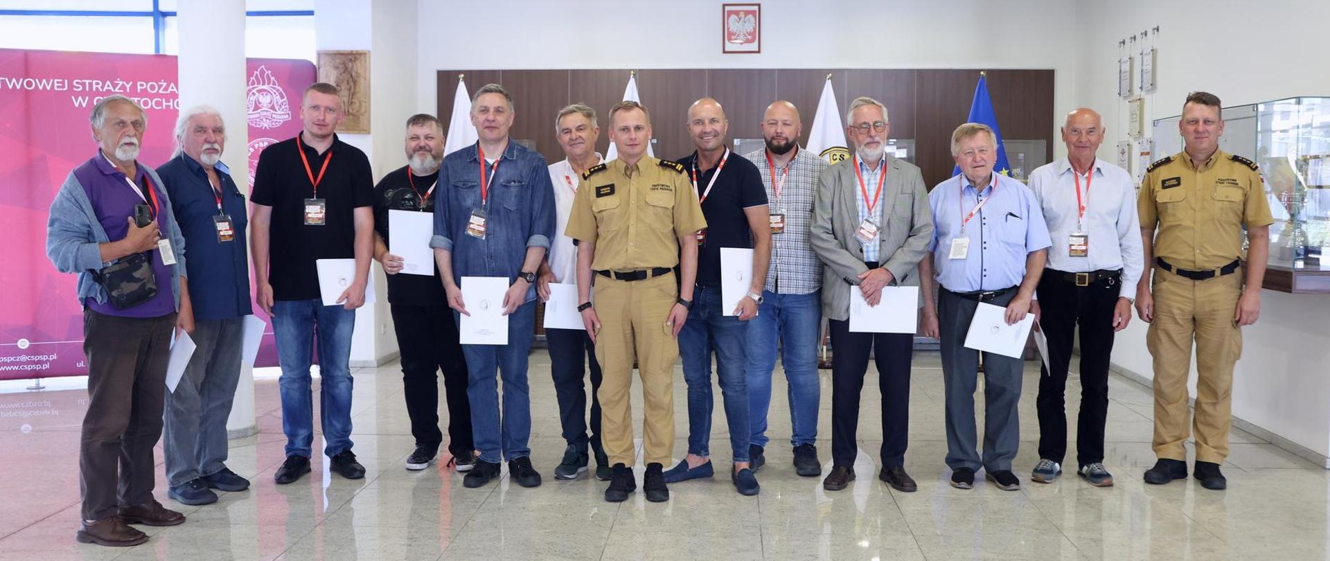 Pamiątkowe zdjęcie grupowe uczestników szkolenia z zakresu ochrony przeciwpożarowej dla rzeczoznawców (11 osób) w towarzystwie Zastępcy Komendanta Centralnej Szkoły PSP oraz oficera CS PSP